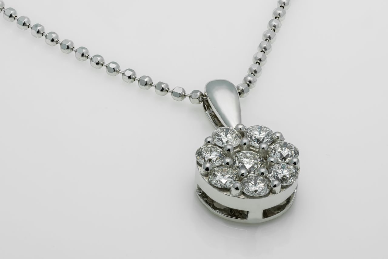 A close-up shot of a luxury diamond pendant necklace with a shiny metallic chain.