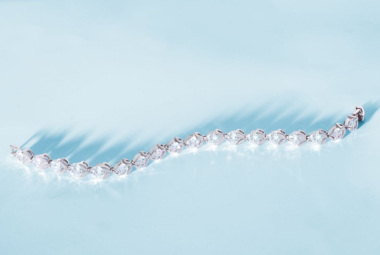 Luxurious diamond bracelet elegantly displayed on a soft blue background.